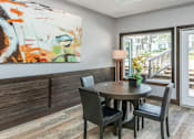 Thumbnail 7 of 7 - A dining room with a round table and chairs.
