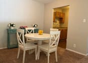 Thumbnail 6 of 8 - A dining room with a white table and chairs.