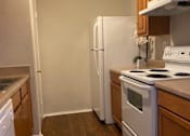 Thumbnail 7 of 8 - A kitchen with a white fridge, white oven, and white stove.