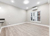 Thumbnail 2 of 8 - an empty living room with white walls and wood flooring