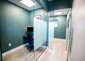 Thumbnail 40 of 47 - a glass walled office with a desk and a chair