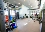 Thumbnail 35 of 47 - a gym with cardio equipment and weights on the floor