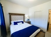 Thumbnail 26 of 47 - a bedroom with a large bed and a blue blanket and pillows