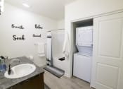Thumbnail 27 of 47 - a small bathroom with a sink and a refrigerator and a washer and dryer