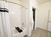 Thumbnail 28 of 47 - a white bathroom with a shower and a tub and a shower curtain