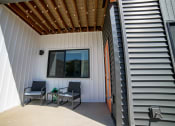 Thumbnail 4 of 47 - a patio with two chairs and a table under a window