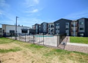 Thumbnail 5 of 47 - an apartment building with a swimming pool and a fence