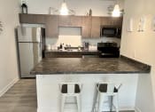 Thumbnail 17 of 47 - a kitchen with a counter top with two stools