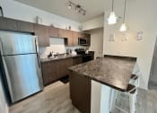 Thumbnail 16 of 47 - a kitchen with stainless steel appliances and a granite counter top
