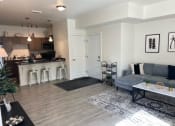 Thumbnail 19 of 47 - a living room and kitchen with a couch and a table