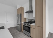 Thumbnail 20 of 63 - A modern kitchen with a stainless steel refrigerator, oven, and range hood at The Franklin Marlboro Apartments, Marlboro