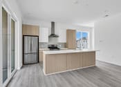 Thumbnail 14 of 63 - A modern kitchen with a stainless steel refrigerator and a wooden island at The Franklin Marlboro Apartments, Marlboro, NJ