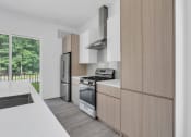 Thumbnail 18 of 63 - A modern kitchen with wooden cabinets and stainless steel appliances at The Franklin Marlboro Apartments, New Jersey, 07746