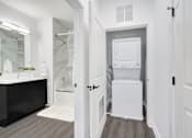 Thumbnail 11 of 11 - a white bathroom with a washer and dryer in the door at The Franklin at Hillsborough Apartments, Hillsborough, New Jersey