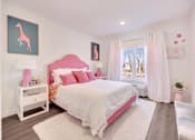Thumbnail 8 of 11 - a pink and white bedroom with a bed and a window at The Franklin at Hillsborough Apartments, Hillsborough, NJ 08844