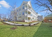 Thumbnail 1 of 11 - a large apartment building with a lawn and sidewalk in front of it at The Franklin at Hillsborough Apartments, Hillsborough, NJ 08844
