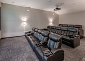 Thumbnail 57 of 63 - A black leather sofa in a room with a projector screen.
