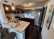 Thumbnail 2 of 22 - a kitchen with stainless steel appliances and granite counter tops