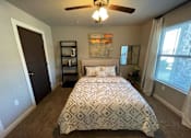Thumbnail 11 of 22 - a bedroom with a bed and a ceiling fan