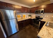 Thumbnail 4 of 22 - a kitchen with stainless steel appliances and marble counter tops