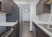 Thumbnail 1 of 12 - a kitchen with stainless steel appliances and wooden floors