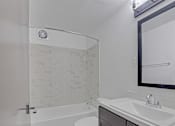 Thumbnail 7 of 12 - a bathroom with a sink and a toilet and a shower