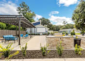 Thumbnail 6 of 11 - a patio with a stone wall and a fire pit