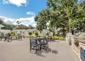 Thumbnail 8 of 11 - an outdoor patio with tables and chairs and trees