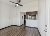 Thumbnail 3 of 11 - an empty living room with a kitchen and a ceiling fan