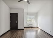 Thumbnail 4 of 11 - an empty living room with wood floors and a black door