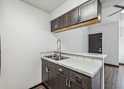 Thumbnail 2 of 11 - a kitchen with a sink and cabinets and a door