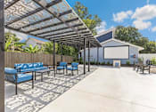 Thumbnail 11 of 11 - a covered patio with blue chairs and a projector screen