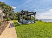 Thumbnail 14 of 19 - a gazebo with benches on the grass near the water