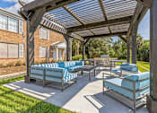 Thumbnail 15 of 19 - a covered patio with lounge chairs and a picnic table