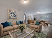 Thumbnail 4 of 19 - a living room and dining room with couches and a table