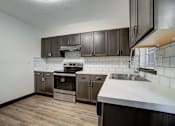 Thumbnail 2 of 19 - an empty kitchen with wooden cabinets and a sink