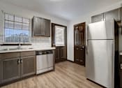 Thumbnail 3 of 19 - an empty kitchen with stainless steel appliances and wooden floors