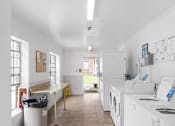 Thumbnail 8 of 19 - an empty laundry room with white appliances and a counter