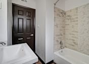 Thumbnail 7 of 19 - a bathroom with a tub and a sink and a door
