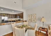 Thumbnail 7 of 14 - a kitchen and dining room with a table and chairs
