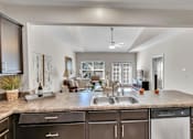 Thumbnail 3 of 14 - view of living room from kitchen with granite counter top and kitchen island and living room
