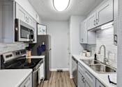Thumbnail 1 of 13 - a kitchen with white cabinets and stainless steel appliances