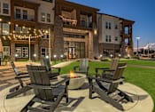 Thumbnail 2 of 35 - a patio with chairs and a fire pit in front of a building