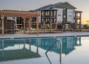 Thumbnail 4 of 35 - a swimming pool with a building in the background