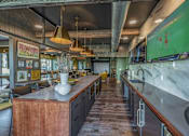 Thumbnail 14 of 35 - a restaurant with a long bar and a green painting on the wall