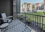 Thumbnail 18 of 35 - a patio with a chair and a table on a balcony