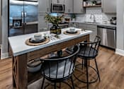Thumbnail 28 of 35 - a kitchen with a large island with three chairs