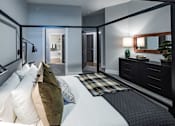 Thumbnail 31 of 35 - a bedroom with a bed and a dresser and a mirror