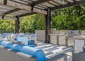 Thumbnail 17 of 18 - a swimming pool with a wall of plants and a blue water feature at The Lorient Apartments, Florida, 32514