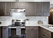 Thumbnail 1 of 18 - a kitchen with stainless steel appliances and wooden cabinets at The Lorient Apartments, Pensacola, FL, 32514